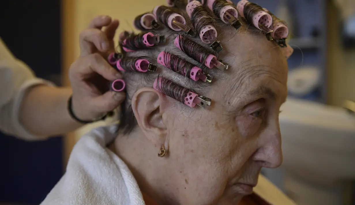 Maribel Elizondo, 90 tahun, menata rambutnya di salon rambut di panti jompo Ibaneta, di desa kecil Erro, sekitar 30 km (18 mil) dari Pamplona, Spanyol utara, Senin, (22/3/2021). Setiap minggu, pada Senin, penata rambut Gloria Cerdan melayani penghuni di panti jompo. (AP Photo/Alvaro Barrientos)