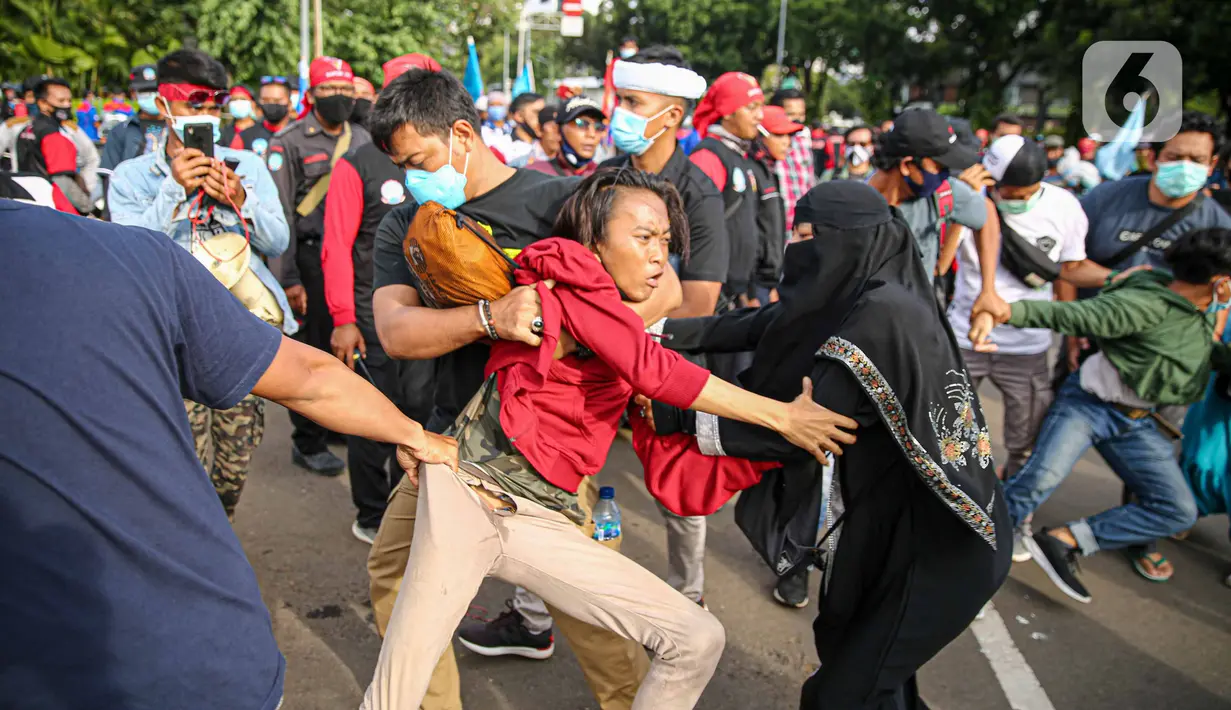 Petugas kepolisian mengamankan massa yang diduga hendak berbuat kericuhan saat aksi unjuk rasa di kawasan Patung Kuda, Jakarta, Kamis (22/10/2020). Penangkapan dilakuka  untuk mencegah hal hal yang tak di inginkan saat unjuk rasa. (Liputan6.com/Faizal Fanani)