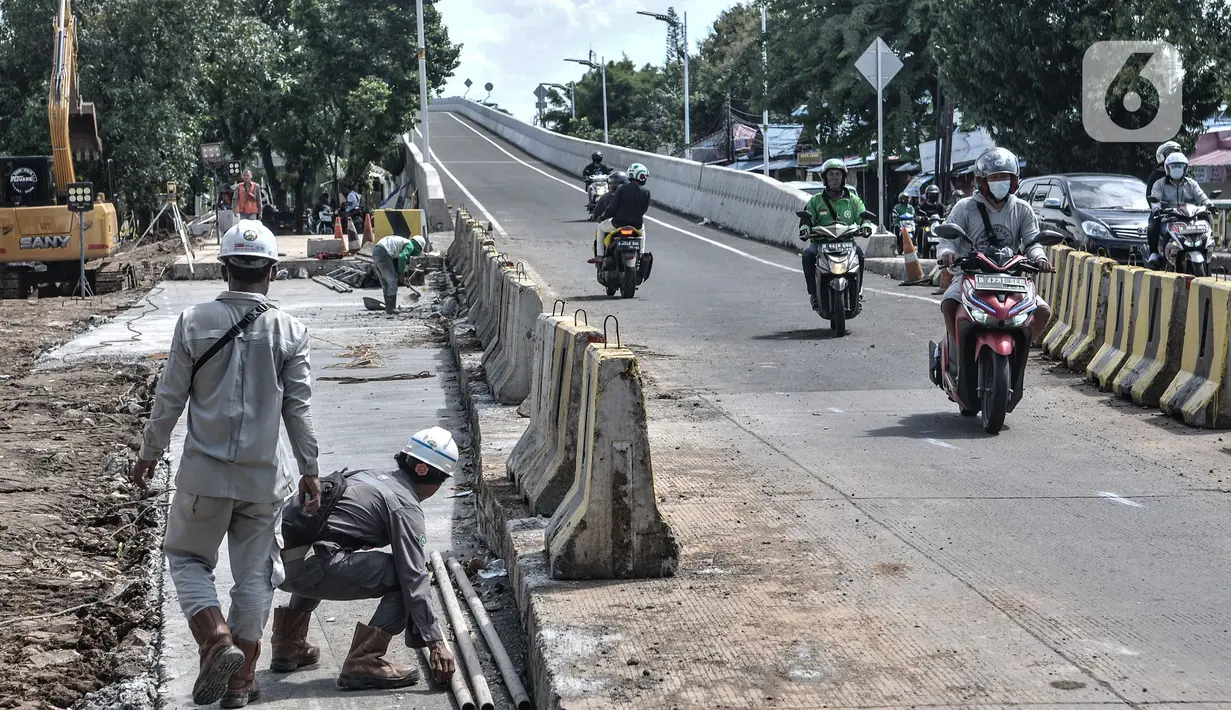 Pengendara motor melintasi pekerja yang beraktivitas saat menerobos flyover tapal kuda Lenteng Agung, Jakarta, Minggu (28/2/2021). Peristiwa ini dapat membahayakan pengendara sepeda motor karena aktivitas pembangunan flyover masih berlangsung. (merdeka.com/Iqbal S Nugroho)