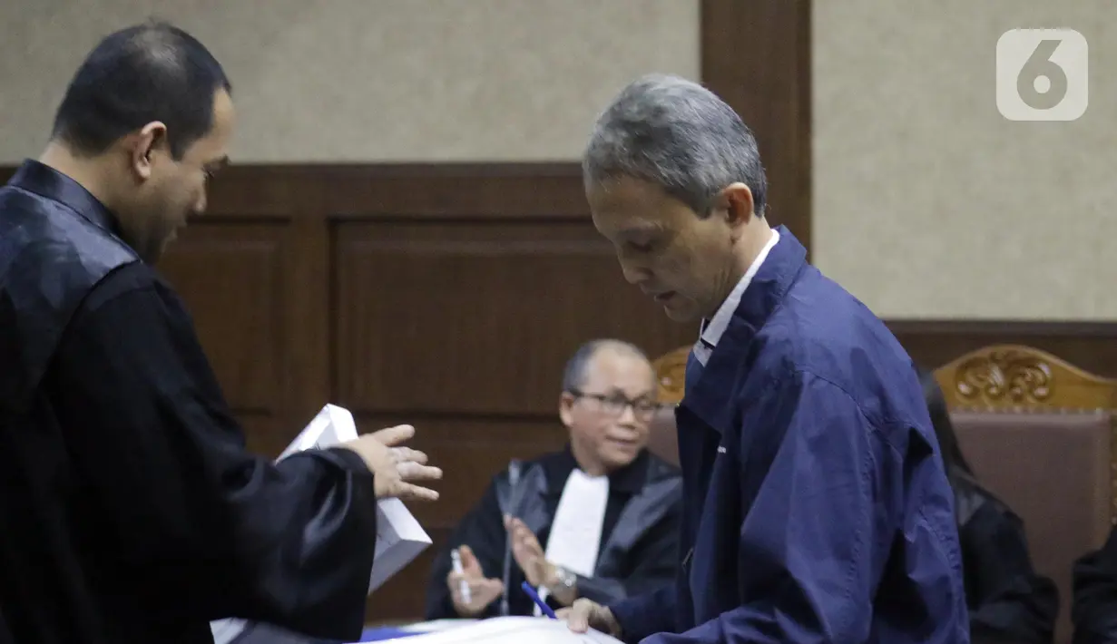 Terdakwa dugaan suap proyek pengadaan di lingkungan PT Krakatau Steel, Wisnu Kuncoro (kanan) menerima surat tuntutan saat sidang di Pengadilan Tipikor, Jakarta, Rabu (16/10/2019). Wisnu Kuncoro dituntut 2 tahun penjara denda Rp 100 juta subsider 3 bulan kurungan. (Liputan6.com/Helmi Fithriansyah)