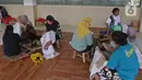 Perajin menyelesaikan salah satu tahapan produksi batik Marunda di Rusunawa Marunda, Jakarta, Selasa (14/7/2020). Pembuatan batik Marunda dimulai dengan melukis pola, mencelup, hingga memberikan warna. (Liputan6.com/Herman Zakharia)