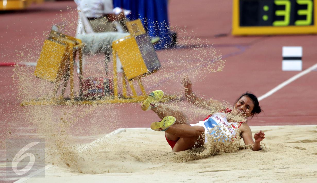 Atlet putri Indonesia, Maria Londa saat mendarat usai melakukan lompatan di nomor lompat jangkit di National Stadium, Singapura, Kamis (11/6/2015). Maria mencatat lompatan sejauh 13,75 meter dan berhasil meraih emas. (Liputan6.com/Helmi Fithriansyah)