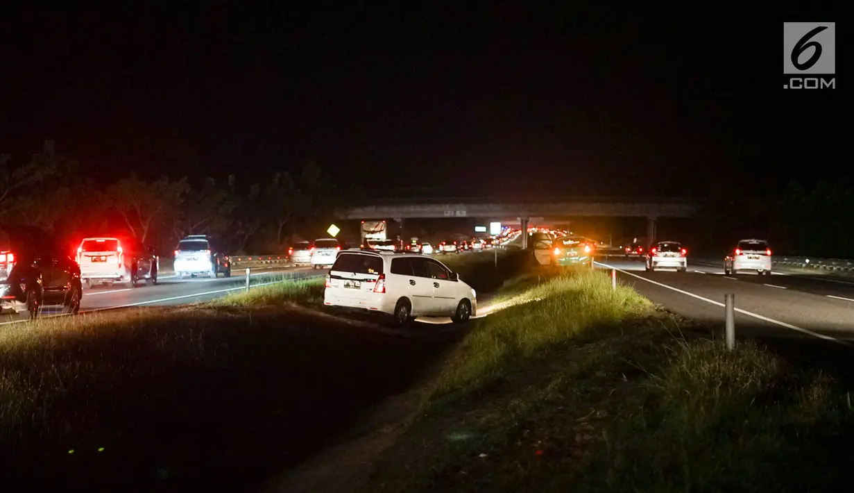 Sejumlah kendaraan yang didominasi pemudik menerobos parit pembatas untuk pindah jalur di Jalan Tol Cikopo - Palimanan KM 135, Jawa Barat, Sabtu (8/6/2019). Padatnya arus balik di ruas tol itu membuat sebagian pengemudi berpindah jalur untuk menghindari kemacetan. (Liputan6.com/Immanuel Antonius)