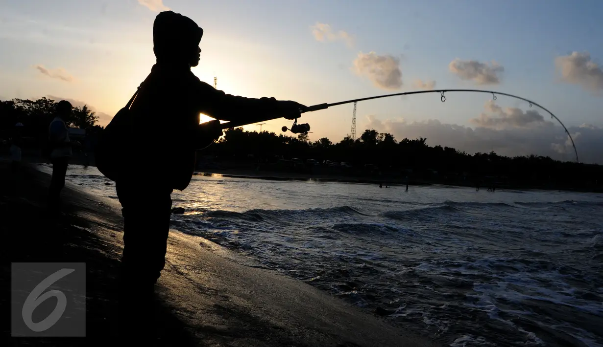 Warga memancing di tepian Pantai Teluk Penyu Kabupaten Cilacap, Jawa Tengah,Jumat (29/7). Pantai Teluk Penyu terletak di kecamatan Cilacap Selatan dengan jarak 2 km dari pusat kota. (Liputan6.com/Helmi Afandi)