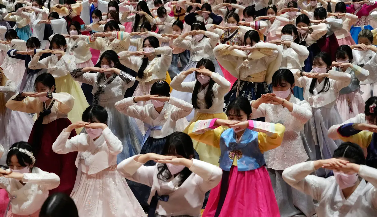 Siswa sekolah menengah atas yang mengenakan pakaian tradisional membungkuk saat upacara kelulusan dan kedewasaan bersama di Sekolah Menengah Wanita Dongmyung, Seoul, Korea Selatan, 7 Februari 2023. Sekolah menengah atas di Korea Selatan mengajar siswa selama tiga tahun, dari kelas satu (usia 15–16) hingga kelas tiga (usia 17–18), dan siswa biasanya lulus pada usia 17 atau 18 tahun. (AP Photo/Ahn Young-joon)