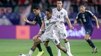 Gelandang Jepang, Wataru Endo (kiri), berebut bola dengan gelandang Indonesia, Beckham Putra Nugraha (tengah), dalam pertandingan kualifikasi Piala Dunia Grup C Asia antara Jepang dan Indonesia di Osaka pada 10 Juni 2025. (PAUL MILLER/AFP)