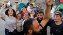 Para pengunjuk rasa anti-pemerintah bergembira setelah PM Lebanon Saad Hariri mengumumkan pengunduran dirinya, di depan istana pemerintahan di Beirut, Selasa (29/10/2019). PM Hariri mengundurkan diri setelah berlangsung aksi unjuk rasa besar-besaran dalam dua minggu terakhir. (AP/Bilal Hussein)