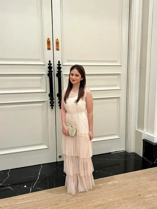 Tissa Biani terlihat anggun mengenakan sleeveless dress dengan detail tile ruffle nuansa ivory cream. Ia melengkapi penampilannya dengan clutch berwarna silver. [@tissabiani].