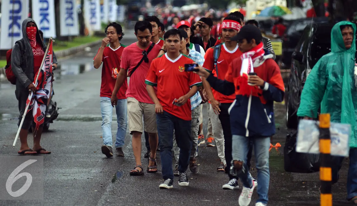 Pendukung Timnas Indonesia berjalan menuju areal Stadion Pakansari, Bogor (3/12). Timnas Indonesia akan melakoni laga semifinal pertama Piala AFF 2016 melawan Vietnam di Stadion Pakansari Kab Bogor. (Liputan6.com/Helmi Fithriansyah)