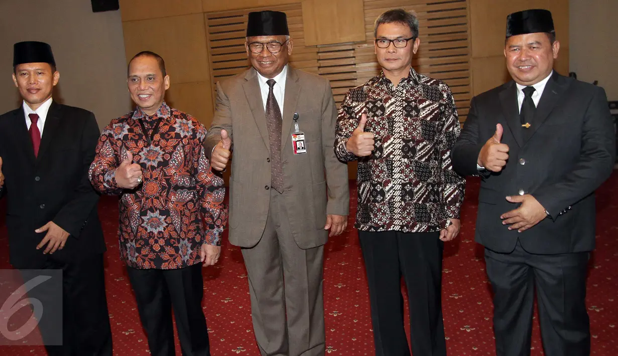 Plt Ketua KPK Taufiqurachman Ruki (tengah) didampingi Direktur Penyidikan baru Kombes Pol Aris Budiman (kiri) dan Kepala Biro Hukum baru Kombes Pol Setiadi (kanan) berfoto bersama usai upacara pelantikan di Jakarta, Rabu (16/9).(Liputan6.com/Helmi Afandi)