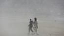 Pria Afghanistan berjalan saat badai pasir di pinggiran Kabul, Afghanistan (25/8/2020). Sebuah badai pasir hebat melanda Kabul. Badai menyebabkan jarak pandang jadi berkurang. (AP Photo / Rahmat Gul)