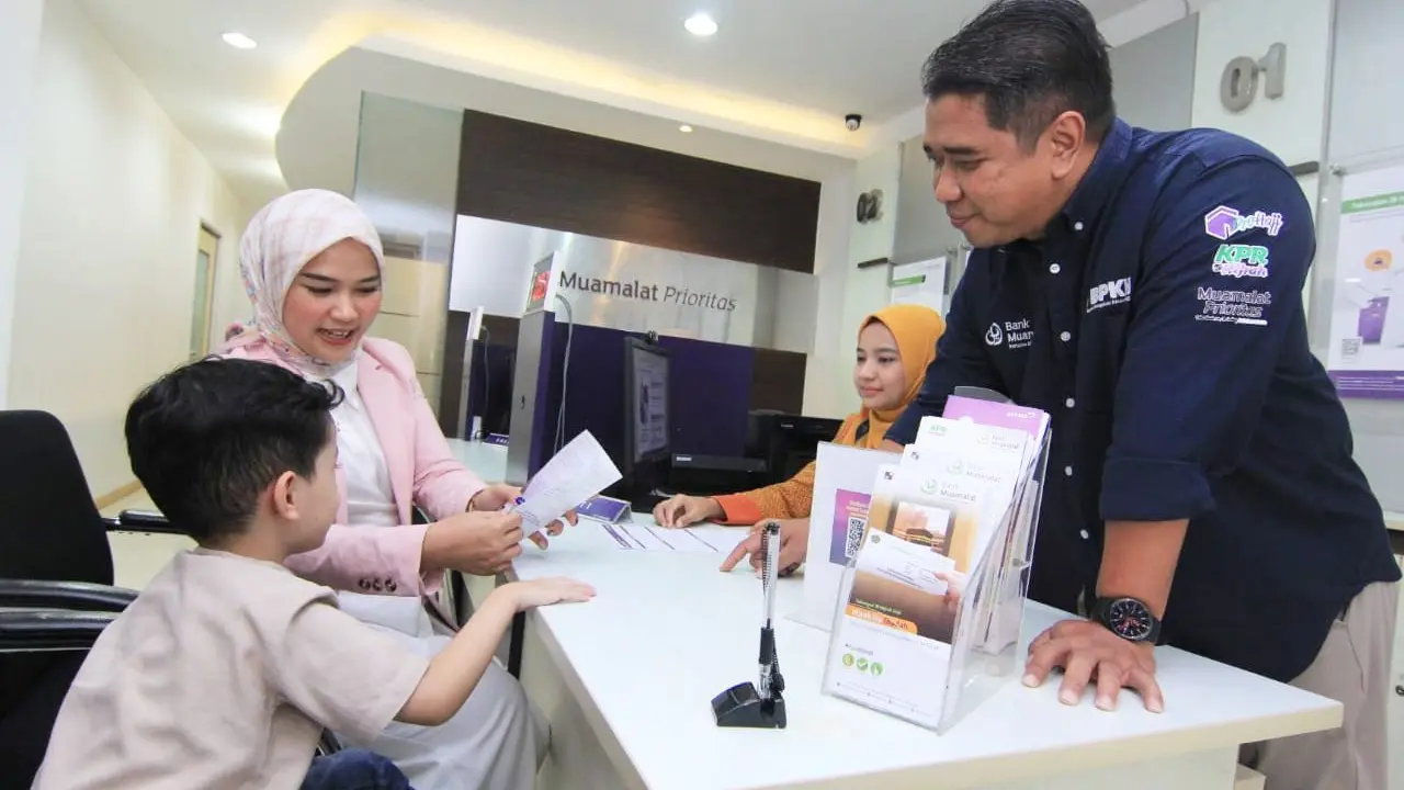 Pelaksana Tugas Regional CEO Jakarta West Bank Muamalat Erick Ermawan (kanan) menyaksikan proses pembukaan rekening tabungan haji anak oleh salah satu nasabah di kantor cabang Bank Muamalat Melawai, Jakarta Selatan. (Dok Bank Muamalat)