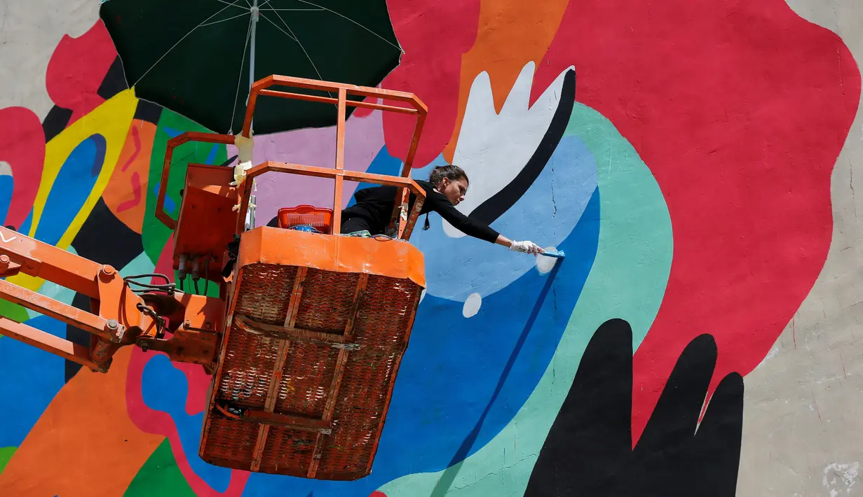 Seniman asal Brasil, Tarsila Schubert saat membuat mural di Museum Seni Terbuka, Kota Amman, Yordania, Kamis (29/9). Aksi melukis mural yang dilakukan Tarsila tersebut untuk mengampanyekan pentingnya pemberdayaan perempuan. (REUTERS/Muhammad Hamed)