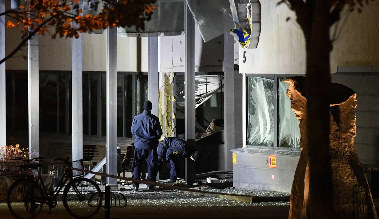 Petugas mengecek kantor polisi setelah ledakan dahsyat di pintu masuk utama di Helsingborg, Swedia (18/10). Tidak ada korban dalam ledakan yang terjadi di kantor polisi tersebut. (AFP Photo/TT News Agency /Johan Nilsson/Sweden Out)