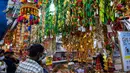 Orang-orang berjalan melintasi sepanjang toko yang menjual ornamen dan dekorasi menjelang Diwali, festival cahaya bagi umat Hindu, di distrik Little India di Singapura pada 23 Oktober 2020. (Photo by Roslan RAHMAN / AFP)