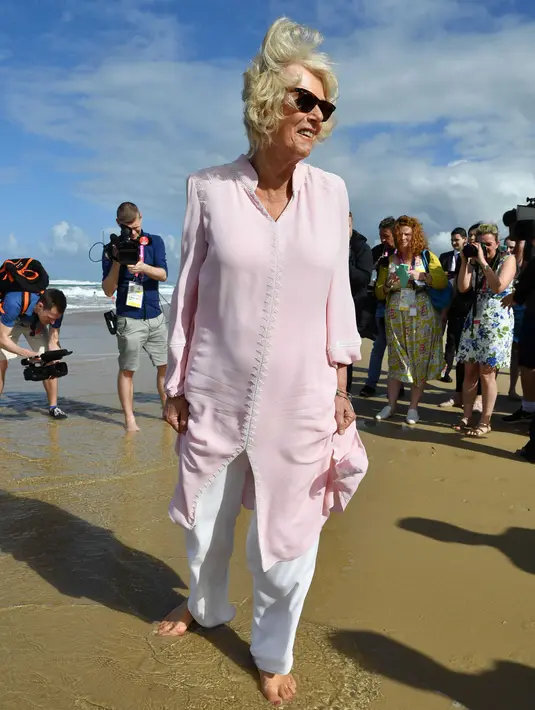 Istri Pangeran Charles, Duchess of Cornwall Camilla berjalan tanpa alas kaki di atas pasir pantai saat mengunjungi Broadbeach di Gold Coast, Kamis (5/4). Pangeran Charles dan Camilia ke Australia untuk menghadiri pembukaan Commonwealth Games. (AP Photo)