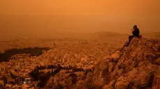 Langit di Yunani selatan berubah menjadi oranye pada hari Selasa ketika awan debu yang tertiup melintasi Laut Mediterania dari Afrika Utara menyelimuti Acropolis dan landmark Athena lainnya. (Angelos TZORTZINIS / AFP)