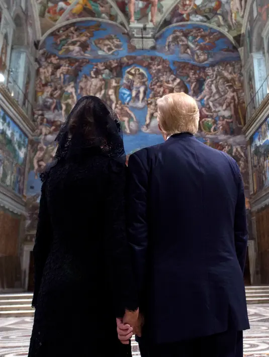 Presiden AS,  Donald Trump didampingi Ibu Negara, Melania Trump melihat langit-langit Kapel Sistina saat mengunjungi Vatikan, (24/5). Melania Trump mengenakan penutup kepala hitam saat menemui Paus. (L'Osservatore Romano/Pool Photo via AP)
