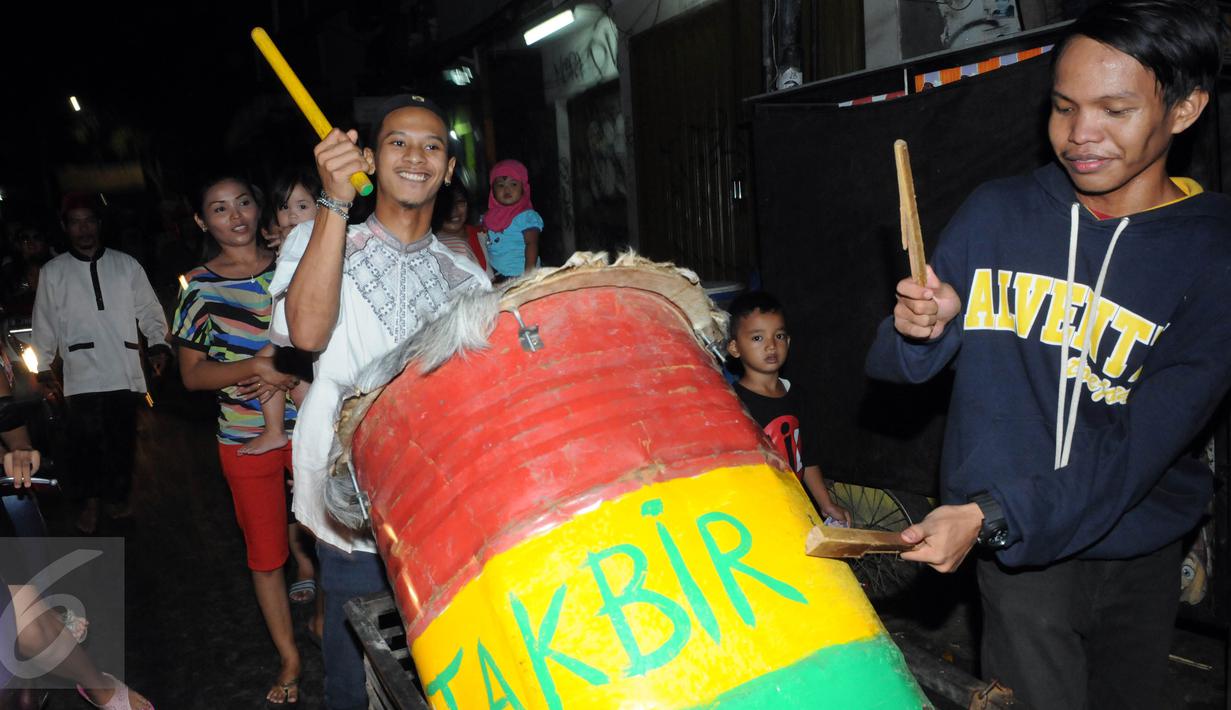 Warga memukul bedug sambil mengumandangkan takbir di kawasan tanah abang, Jakarta,Selasa (5/7). Bagi Umat Muslim Indonesia mengumandangkan Takbir ialah sebagai suatu tanda menyambut hari Raya Idul Fitri 1437 Hijriah. (Liputan6.com/Helmi Afandi)