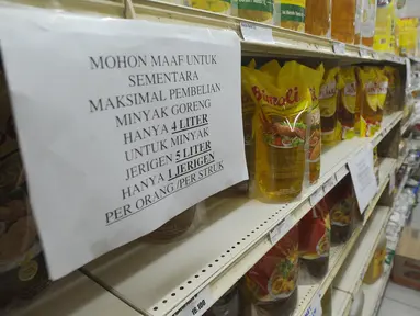 Pembeli berbelanja dekat kertas pemberitahuan pembatasan pembelian di supermarket Kawasan Cirendeu, Tangsel, Rabu (18/3/2020). Satgas Pangan meminta pedagang membatasi penjualan bahan pokok yakni beras, gula, minyak goreng dan mi instan untuk menjaga stabilitas harga. (merdeka.com/Arie Basuki)