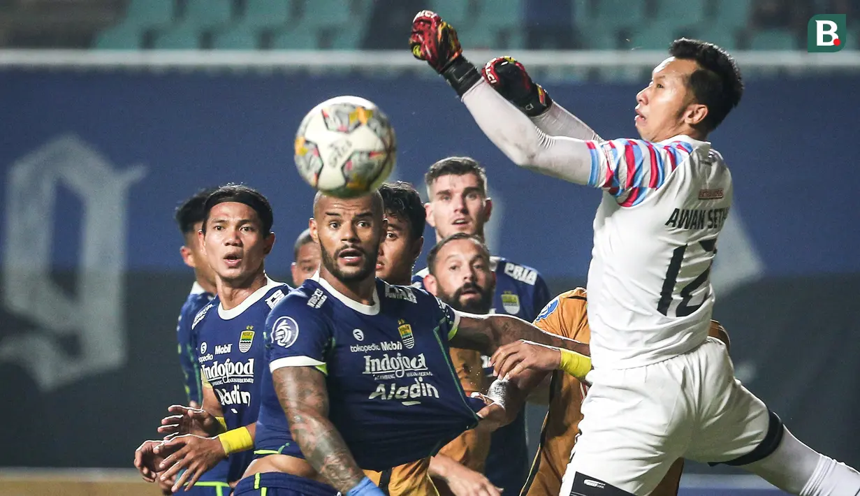 <p>Pemain Persib Bandung, Ciro Alves (tengah) melihat bola yang gagal diantisipasi oleh kiper Bhayangkara FC, Awan Setho pada laga lanjutan BRI Liga 1 2022/2023 antara Persib Bandung melawan Bhayangkara FC di Stadion Pakansari, Bogor, Jumat (24/03/2023). (Bola.com/Bagaskara Lazuardi)</p>