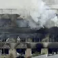 Petugas pemadam kebakaran berjibaku memadamkan api saat kebakaran melanda studio animasi Kyoto Animation di Kyoto, Jepang, Kamis (18/7/2019). Studio tersebut diduga sengaja dibakar oleh seorang. (Kyodo News via AP)