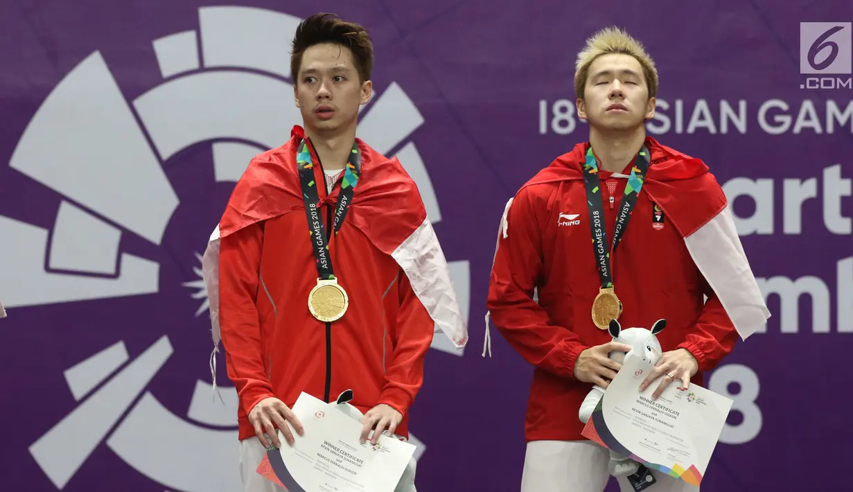 Ganda putra Indonesia, Kevin Sanjaya S/Marcus F Gideon di podium kemenangan usai menumbangkan Fajar Alfian/M Rian Ardianto di Final Bulutangkis Asian Games 2018 di Istora GBK, Jakarta, Selasa (28/8). (Liputan6.com/Helmi Fithriansyah)