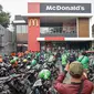 Kerumunan pengemudi ojek online saat antre mengambil pesanan di gerai cepat saji McDonald's Raden Saleh, Jakarta, Rabu (9/6/2021). Puluhan driver ojek online terlihat mengabaikan protokol kesehatan saat mengantre pesanan BTS Meal yang mulai dijual. (Liputan6.com/Faizal Fanani)