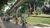 Wisatawan bersepeda mengelilingi obyek wisata Taman Mini Indonesia Indah (TMII) di Jakarta, Minggu (21/6/2020). Setelah tidak beroperasi akibat pandemi, pengelola membuka kembali TMII dengan menerapkan protokol kesehatan pencegahan COVID-19 dan pembatasan pengunjung. (Liputan6.com/Immanuel Antonius)