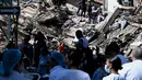 Sejumlah orang mencari korban yang tertimbun  bangunan yang runtuh akibat gempa bumi di Cali, Kolombia, Senin, 10 Agustus 2026 (AFP/ Joaquin Sarmiento)