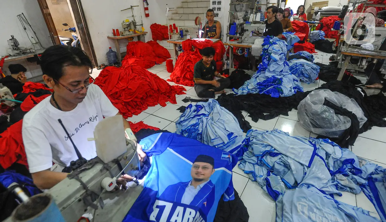 Sejumlah pekerja menjahit kaus partai politik yang telah disablon di sebuah UMKM konveksi sablon rumahan Sinergi Adv, Srengseng Sawah, Jakarta, Rabu Jumat (25/10/2023). (merdeka.com/Arie Basuki)
