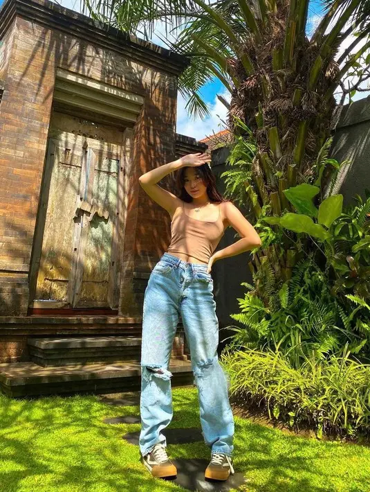 Seperti dalam potret ini, pemilik nama asli Livia Renata ini tampil stylish dengan casual outfit. Dia memadukan cropped tank top dengan ripped jeans dan sneakers warna senada.  (Instagram/livyrenata).