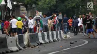 Massa berkerumun saat terjadi bentrok dengan aparat keamanan di kawasan Slipi, Jakarta Barat, Rabu (22/5/2019). Polisi membalas lemparan batu para pengunjuk rasa dengan menembakkan gas air mata. (Liputan6.com/Gempur Muhammad Surya)