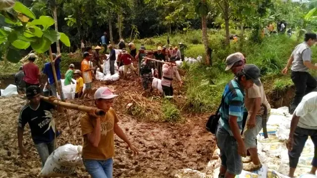 Ratusan warga bersama dengan BPBD Cilacap, relawan, TNI dan Polri menambal tanggul yang jebol dan menyebabkan banjir. (Foto: Liputan6.com/Muhamad Ridlo)