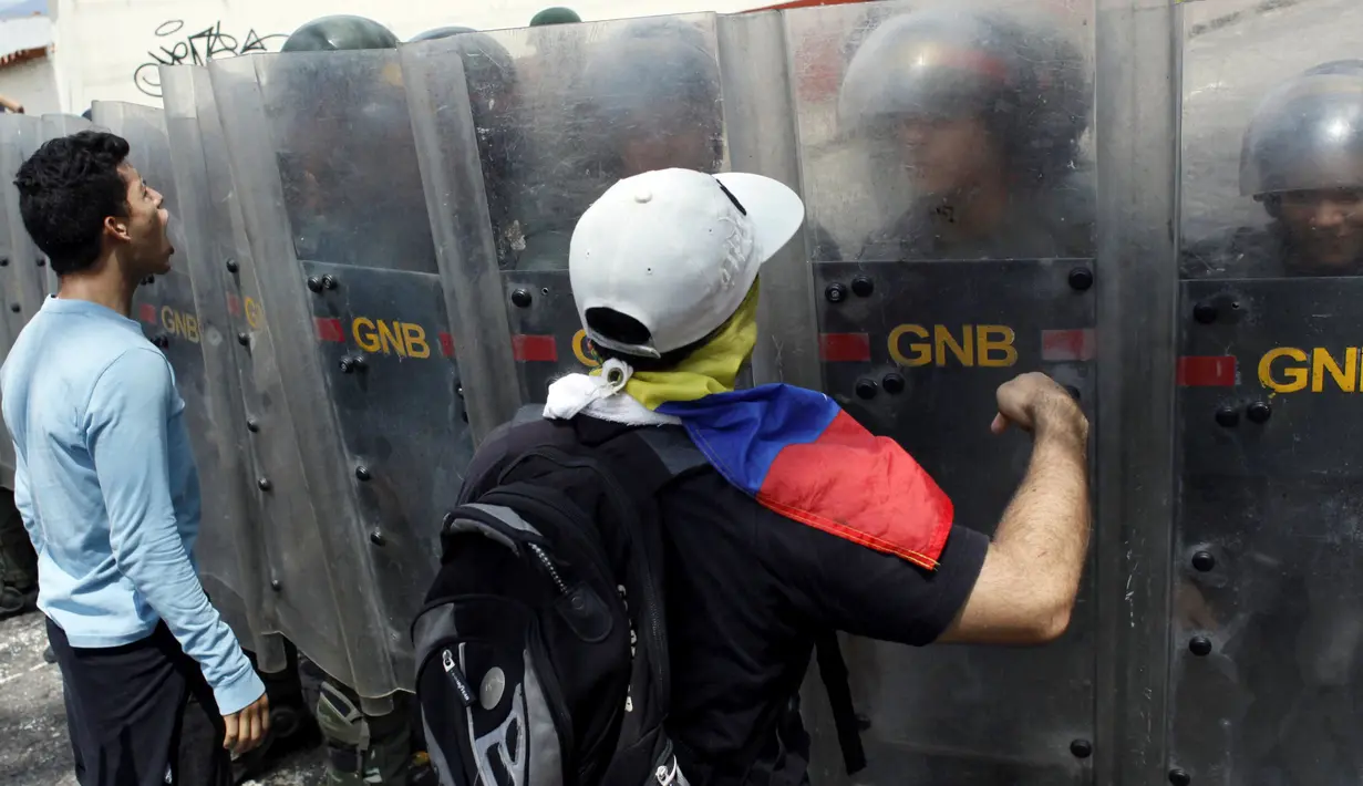 Demonstran bentrok dengan petugas saat unjuk rasa anti-Presiden Nicolas Maduro di San Cristobal, Venezuela (26/10). Aksi unjuk rasa ini tak hanya berlangsung di Caracas, tetapi juga digelar serentak di lokasi lainnya. (REUTERS/Carlos Eduardo Ramirez)