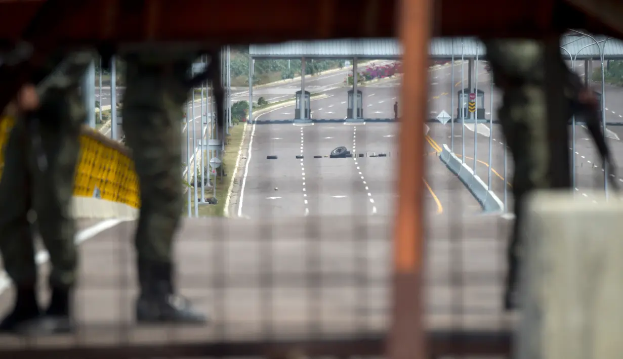 Pasukan militer Venezuela berjaga saat memblokir perbatasan dengan Kolombia di Jembatan Tienditas, Cucuta, Kolombia, Rabu (6/2). Diduga, pemblokiran bentuk kekhawatiran pemerintah berkuasa atas kemungkinan intervensi militer asing. (Raul Arboleda/AFP)
