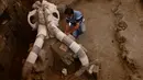 Seorang arkeolog mengamati  fosil mammoth berusia 12.000 - 14.000 tahun, yang ditemukan di Desa Tultepec, dekat Mexico City, 24 Juni 2016. Sisa-sisa binatang itu terkubur enam kaki di bawah jalan pinggiran kota San Antonio Xahuento. (Hector GUERRER /AFP)