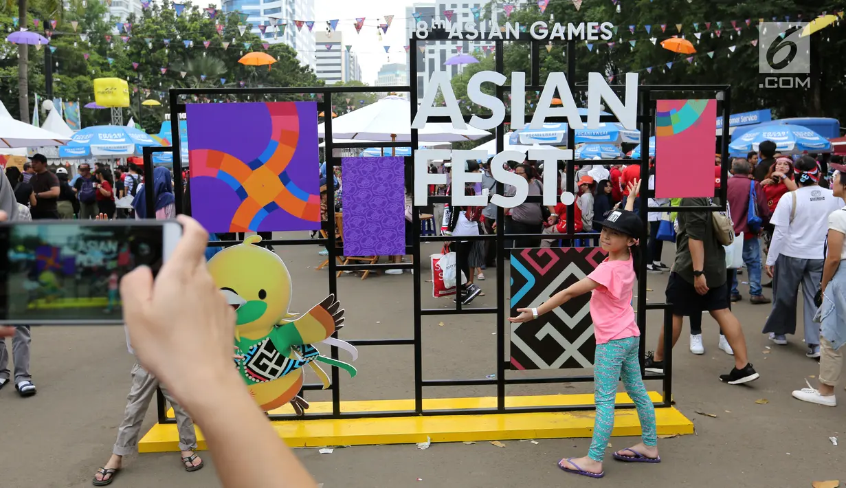Dua anak foto bersama di landmark Asian Festival 2018 di kawasan Gelora Bung Karno Senayan, Jakarta, Minggu (2/9). Mereka memanfaatkan waktu sambil menunggu Closing Ceremony Asian Games 2018. (Liputan6.com/Fery Pradolo)