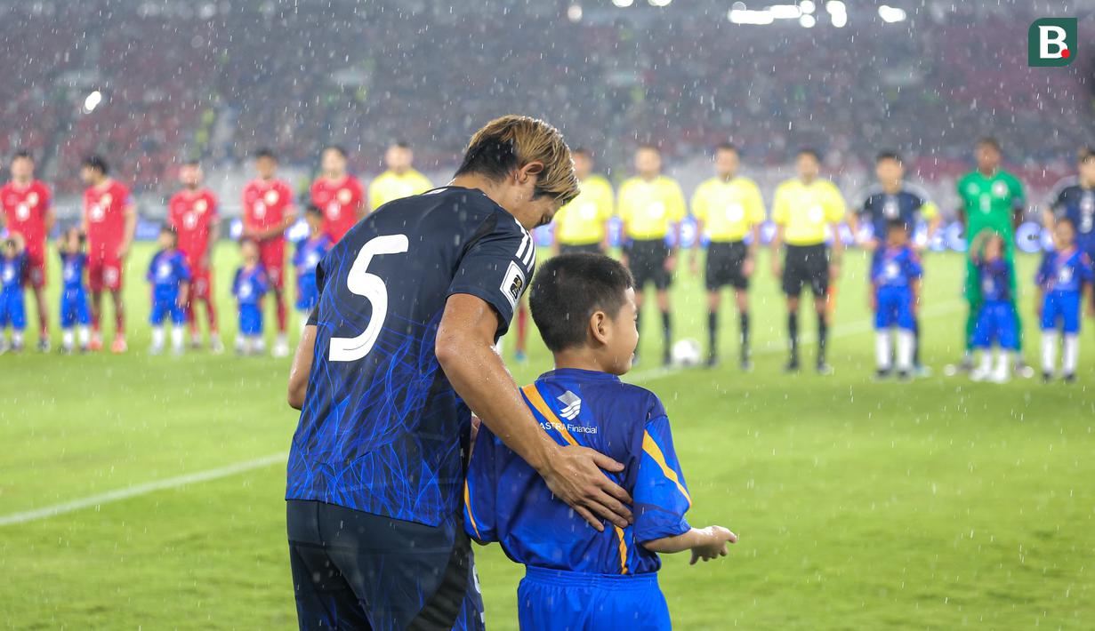 <p>Pemain Jepang, Hidemasa Morita dengan sabar menuntun anak kecil yang bertugas sebagai player escort dalam pertandingan lanjutan putaran ketiga Grup C Kualifikasi Piala Dunia 2026 melawan Timnas Indonesia di Stadion Utama Gelora Bung Karno (SUGBK), Senayan, Jakarta, Jumat (15/11/2024). (Bola.com/Bagaskara Lazuardi)</p>