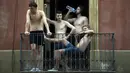 Pemuda nongkrong di balkon di Barcelona, Spanyol, Sabtu (14/8/2021). Spanyol mengalami hari terpanas sepanjang tahun pada hari Sabtu dengan suhu mencapai 46 derajat Celcius. (AP Photo/Joan Mateu Parra)