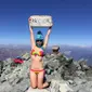 Gigi Wu terlihat mengangkat papan bertuliskan Gunung Yarigatake sambil memakai bikini. (dok. Facebook: Remembering Gigi Wu/Esther Novita Inochi)