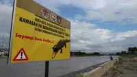 Papan peringatan adanya buaya di Sungai Palu yang dipasang BKSDA Sulteng. (Foto; Liputan6.com/ Heri Susanto).
