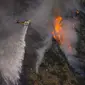 Sebuah helikopter menjatuhkan air ke Ranch Fire di Azusa, California, Amerika Serikat, 13 Agustus 2020. Gelombang panas menyulitkan petugas pemadam kebakaran yang sedang memerangi kebakaran semak dan kebakaran hutan di California Selatan. (AP Photo/Marcio Jose Sanchez)