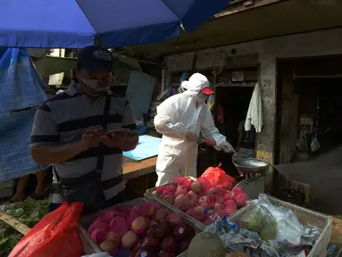 Petugas Palang Merah Indonesia (PMI) melakukan spraying pasar Karang Anyar dengan cairan disinfektan, Jakarta Pusat, Rabu (24/6/2020). Penyemprotan cairan disinfektan yang dilakukan tesebut untuk memutus penyebaran virus corona (COVID-19) pada PSBB Transisi new normal. (merdeka.com/Imam Buhori)