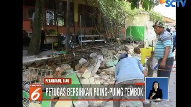 Dua orang tewas setelah tembok SD Negeri 141, Kecamatan Bukitraya, Pekanbaru, Riau, ambruk. Puing-puing tembok pun mulai dibersihkan petugas Dinas Kebersihan Kota Pekanbaru.
