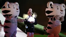 Maskot Olimpiade dan seorang gadis muda berpartisipasi dalam upacara penutupan Olimpiade Musim Dingin PyeongChang 2018 di Pyeongchang, Korea Selatan, 25 Februari 2018. (AP Photo/Natacha Pisarenko)
