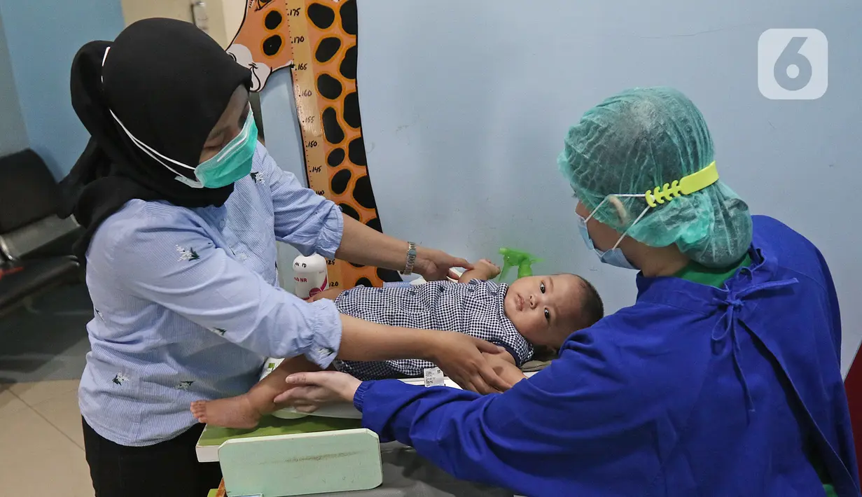 Pasien menimbang anaknya sebelum kontrol ke dokter di Rumah Sakit Ibu dan Anak Tambak, Jakarta, Selasa (22/12/2020). Pemberian bunga dan kue kepada pasien rawat inap dan pasien yang kontrol dilakukan untuk memperingati perayaan Hari Ibu yang jatuh pada 22 Desember. (Liputan6.com/Herman Zakharia)