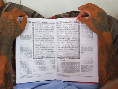Tangan seorang napi terlihat saat membacakan mushaf Al Quran di sebuah penjara di Serang, Jawa Barat pada 27 Maret 2023. (AFP/Dziki Oktomauliyadi)