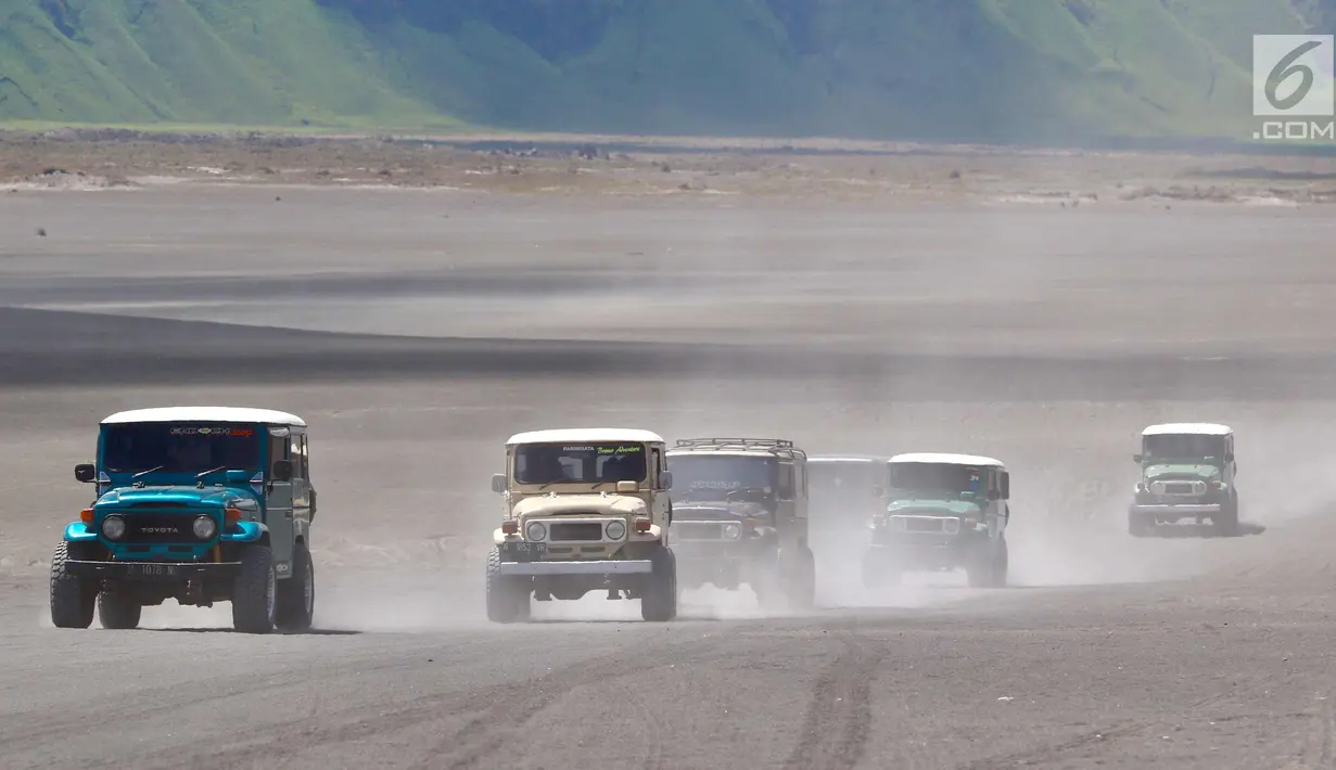 Mobil Toyota jeep melaju kencang membawa wisatawan menuju kawasan Pasir Berbisik di Taman Nasional Bromo Tengger Semeru, Jawa Timur, Sabtu (4/11). Mobil ini hanya melayani wisatawan dari hotel atau home stay keliling TN Bromo. (Liputan6.com/Fery Pradolo)