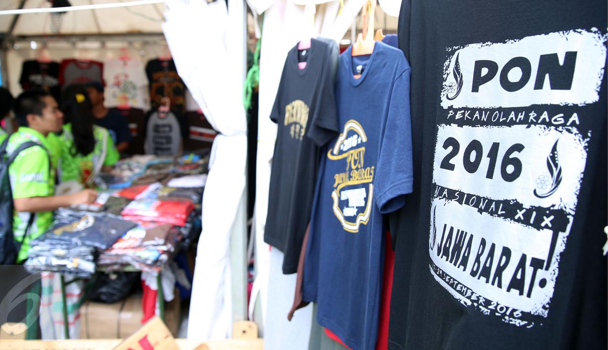 Salah satu anggota kontingen memilih kaos berdesain PON XIX Jabar di GOR Universitas Pendidikan Indonesia, Senin (19/9). Beberapa pedagang memanfaatkan moment PON XIX Jabar untuk menjual beragam pernak pernik. (Liputan6.com/Helmi Fithriansyah) 
